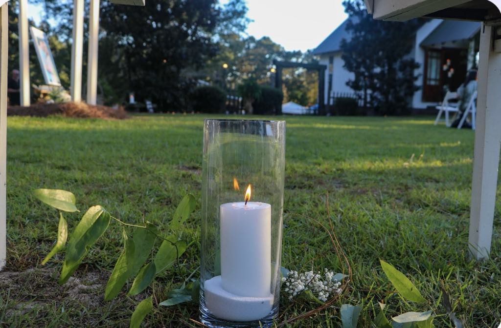 Outdoor wedding decor with candle and greenery